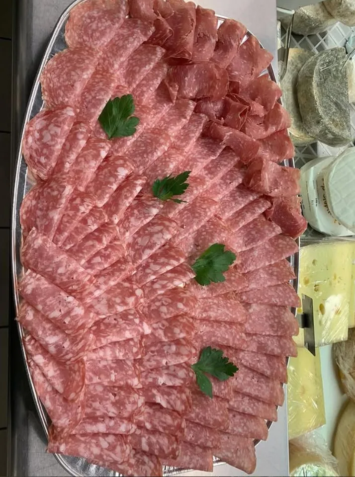 Vassoio di salumi assortiti preparato da TREVANI: salame nostrano, soppressa, salumi italiani disposti con cura, decorati con prezzemolo fresco